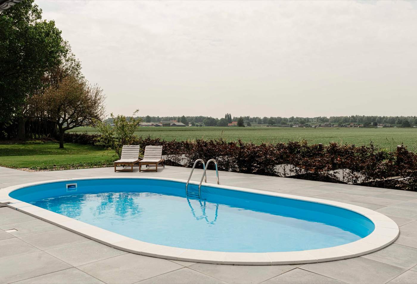 Landelijke tuin met grindoprit, bloeiende borders en volwassen bomen  Van der Lee Hovenier